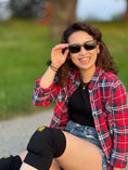 Load image into Gallery viewer, A woman wearing knee pads and wenge wood sunglasses sits on the ground, ready for an outdoor activity.