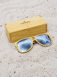 Load image into Gallery viewer, Yellowheart wooden sunglasses with silver polarized lenses and a box on sandy beach.
