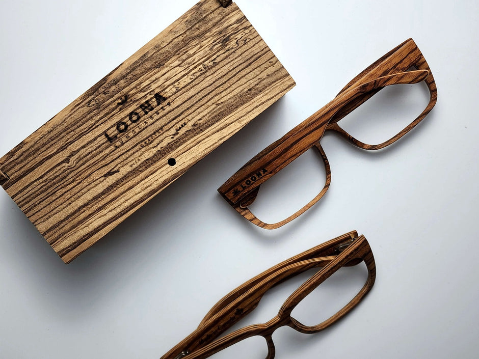 Zebrawood Wooden eyeglasses and case on a white background, displaying a rustic texture and engraved branding Loona Sunglasses